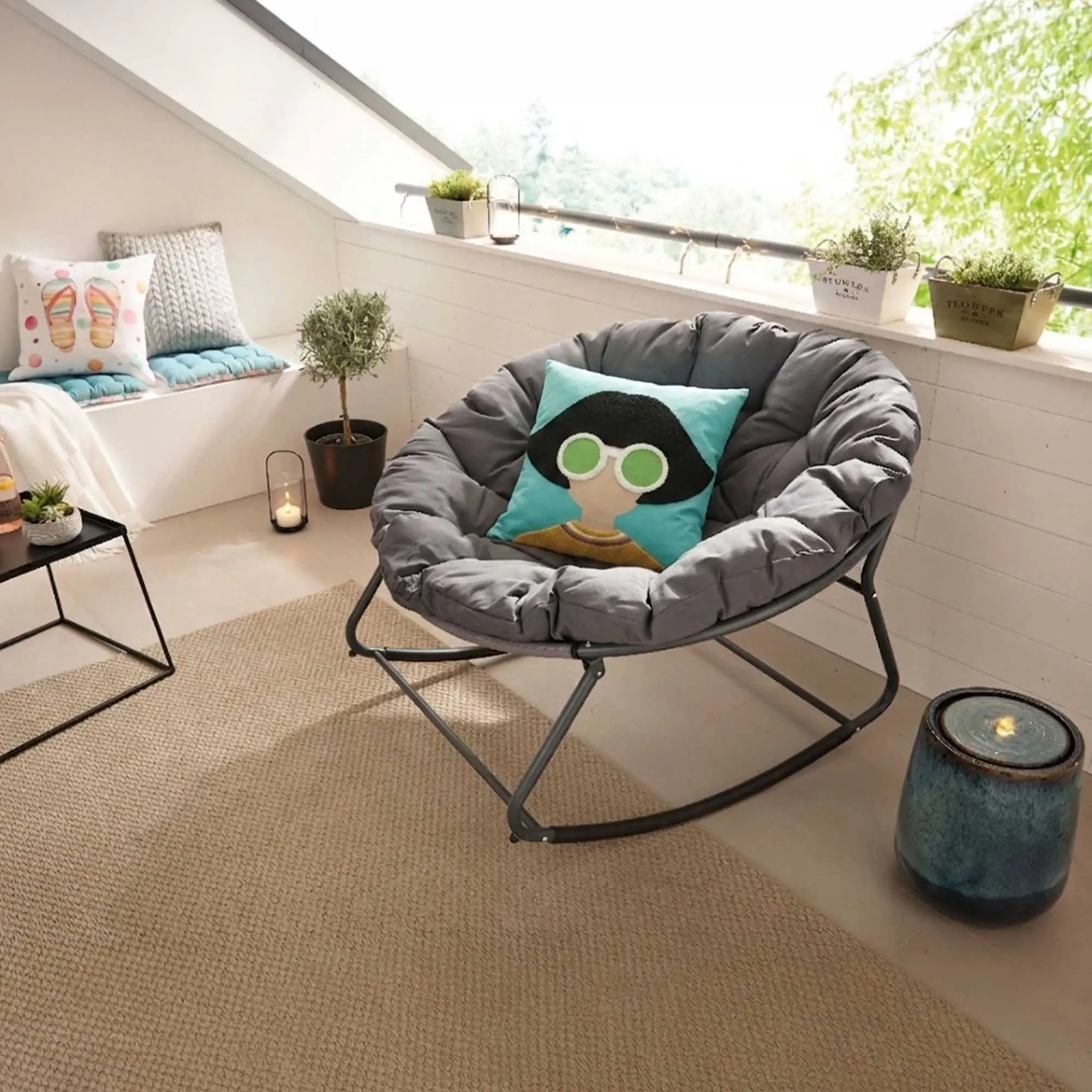 Idée déco : coin lecture douillet avec fauteuil à bascule gris, coussins, plante et tapis