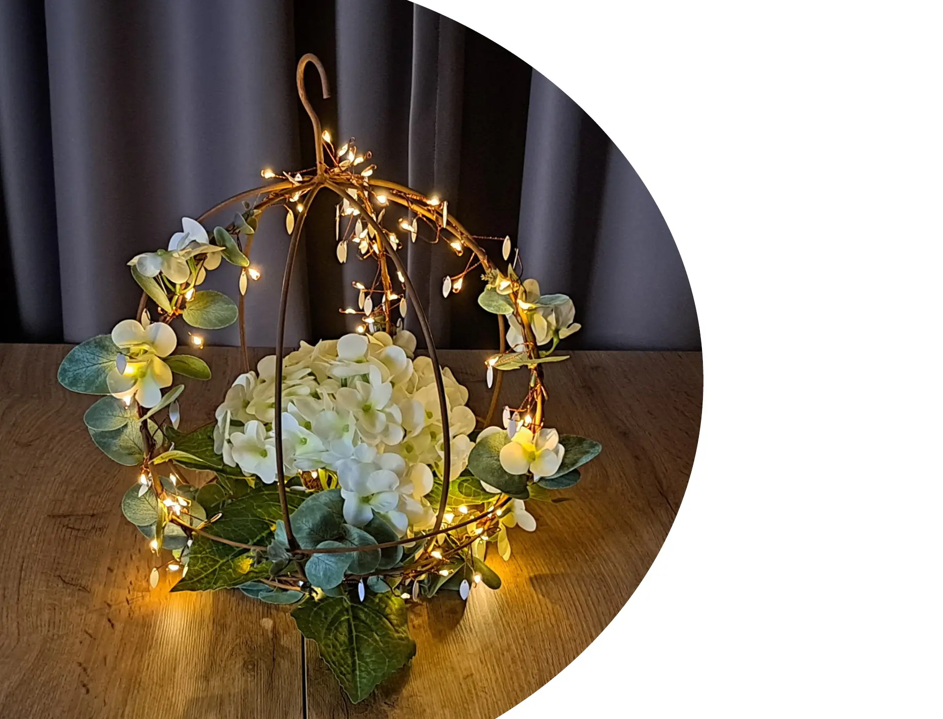 Décoration lumineuse LED : boule suspendue en métal avec guirlande lumineuse aux couleurs chaudes, fleurs blanches et feuilles vertes