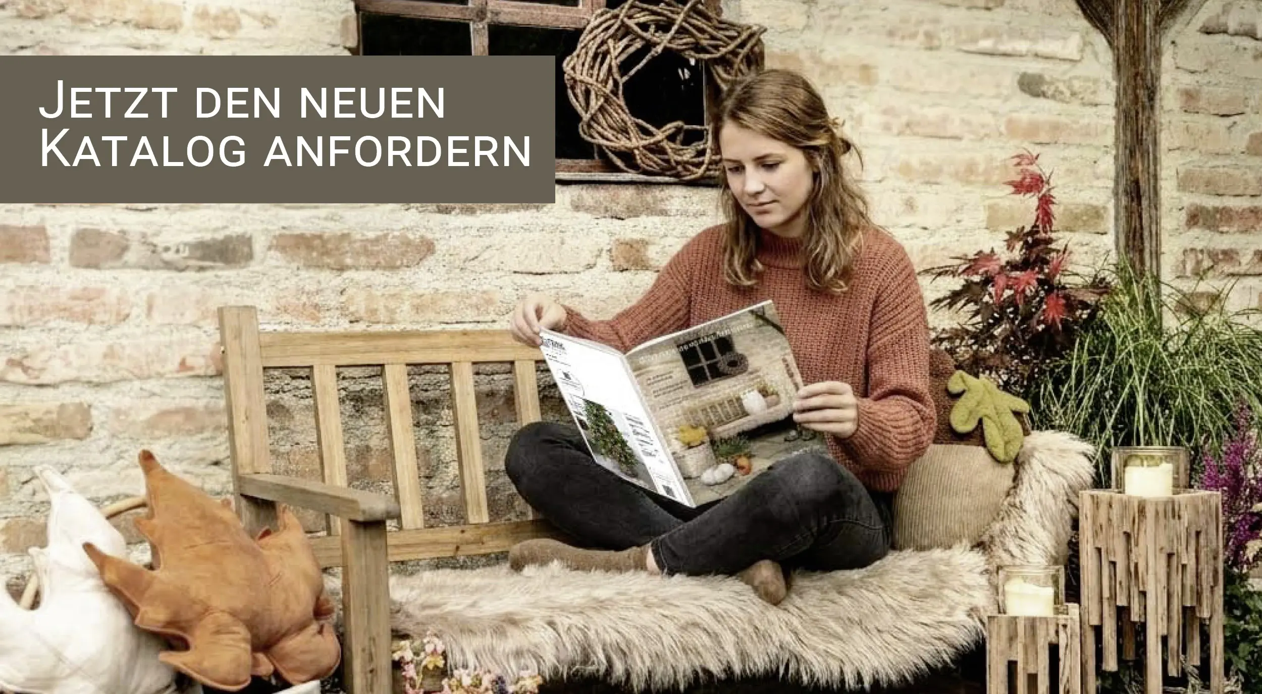 Commande de catalogue : banc en bois décoré sur le thème de l'automne, avec des accessoires de décoration et une personne en train de lire un catalogue de décoration