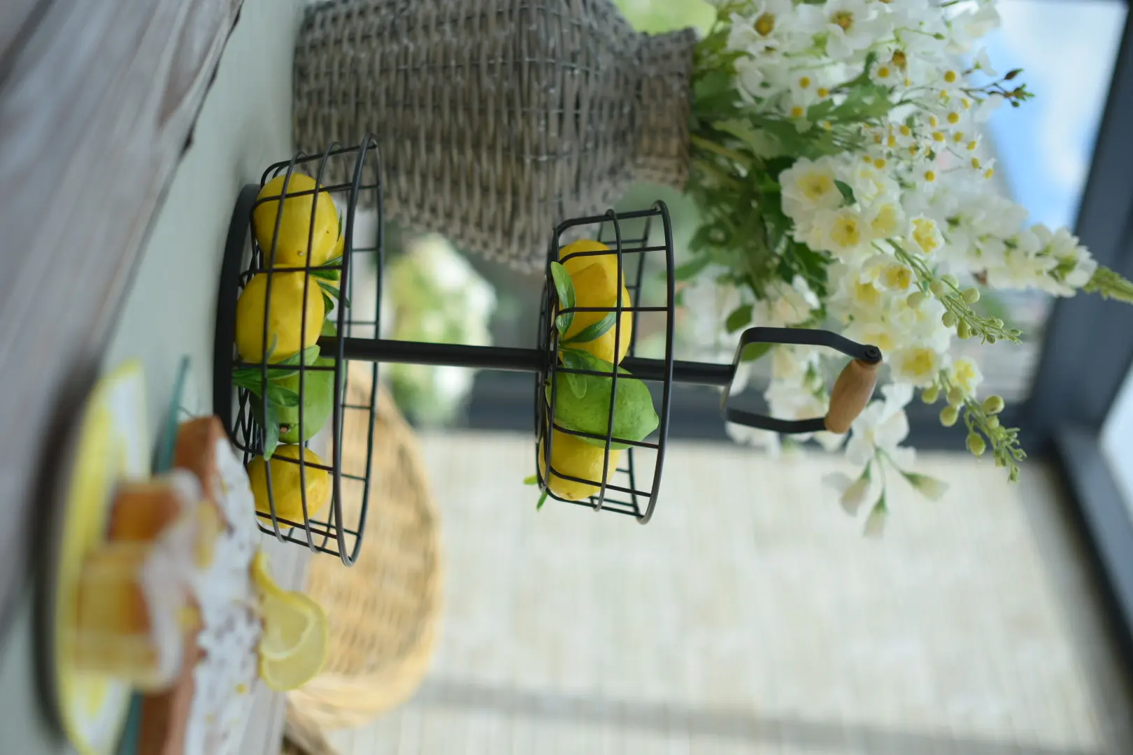 Décoration de table : étagère noire avec des citrons et des fleurs blanches pour une décoration estivale