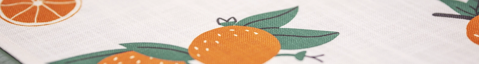 Wohntextilien: heller Stoff mit Orangenmotiv als frische Tisch‑ oder Küchendeko