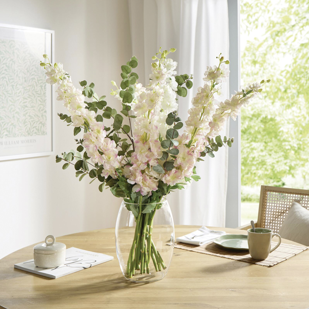 Heller Blumenstrauß aus weiß‑roséfarbigen Blüten und Eukalyptus in Glasvase