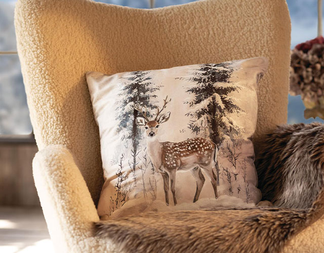 Textiles d'intérieur : coussins à motif de chevreuil sur fond de forêt hivernale, pour une décoration chaleureuse dans le style chalet