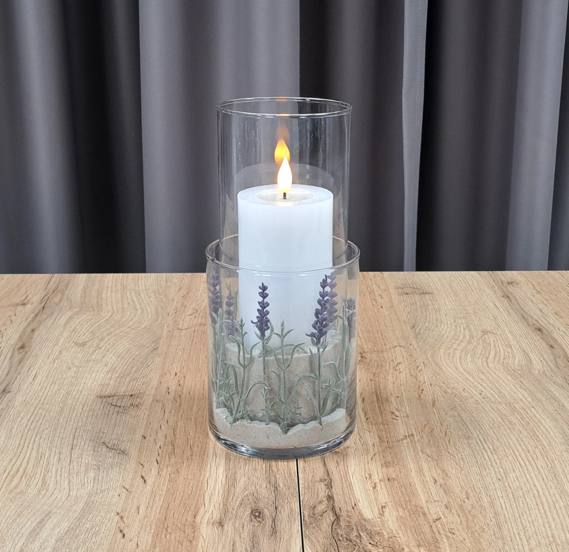 Décoration avec bougie : bocal cylindrique contenant une bougie blanche et un motif de lavande, pour une décoration de table apaisante