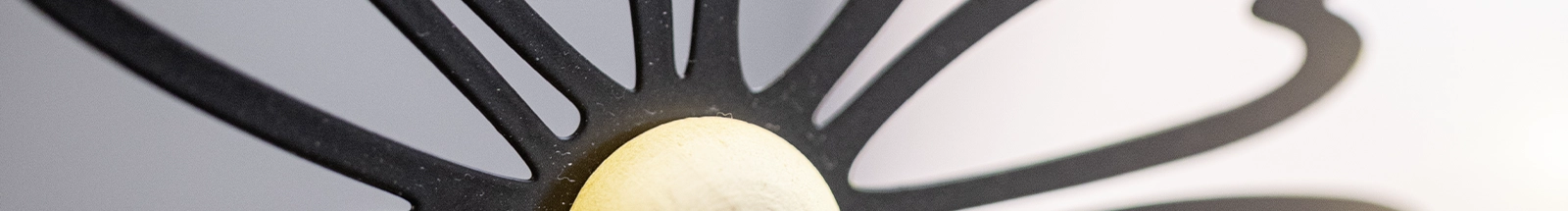 Dekoration: schwarzes Metall-Dekoelement mit hellem Holzdetail als modernes Wohnaccessoire