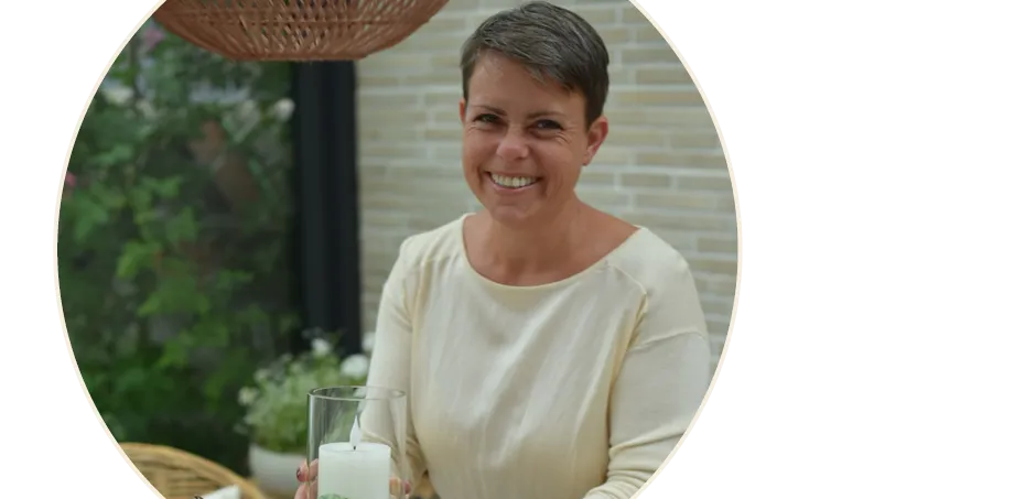 Idée déco : une personne tenant une bougie dans une lanterne, dans un salon décoré sur le thème de l'automne, dans un style maison de campagne