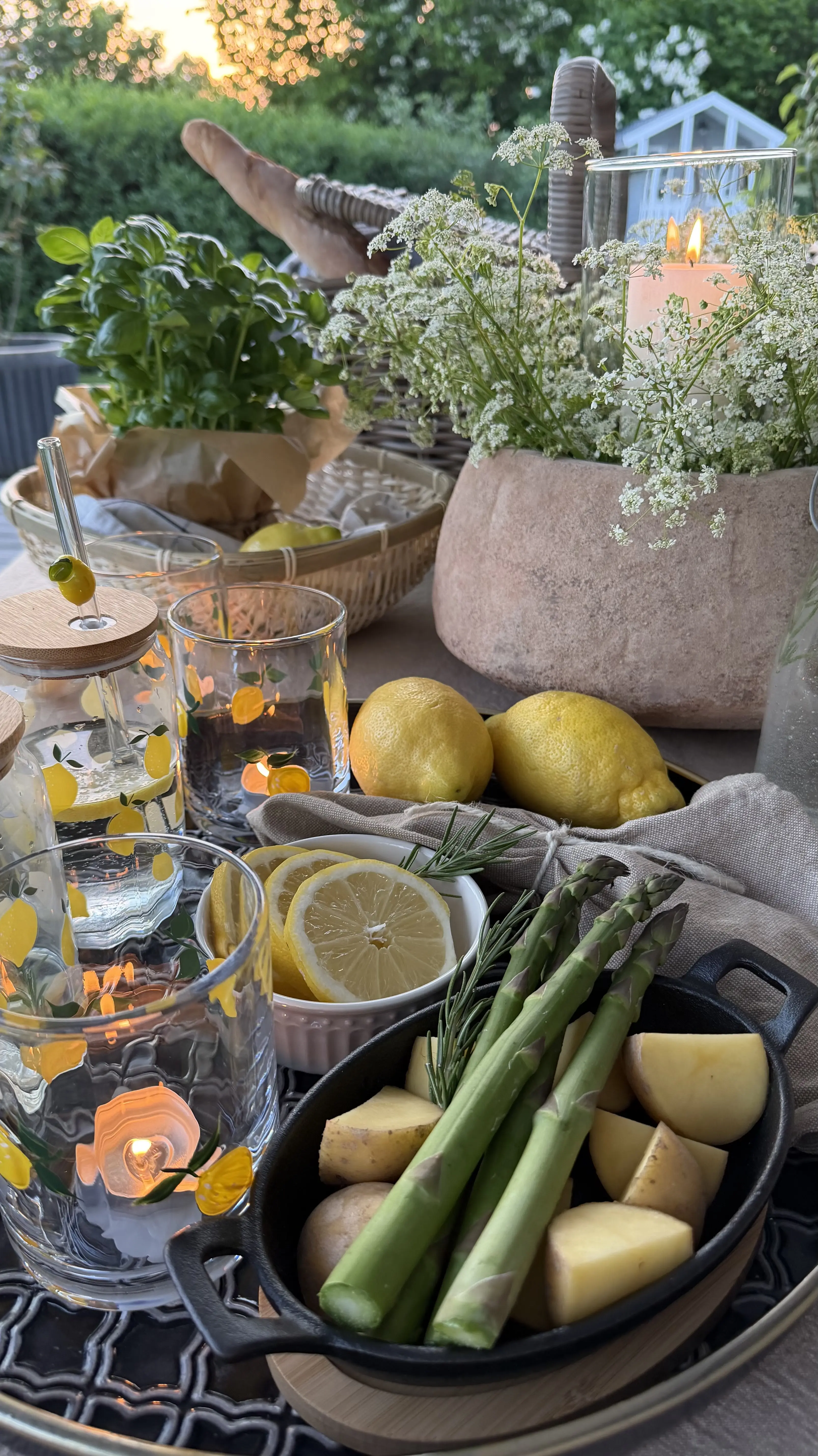 Décoration de table : table de jardin avec des citrons, des asperges, des verres et des bougies pour une décoration d'extérieur estivale