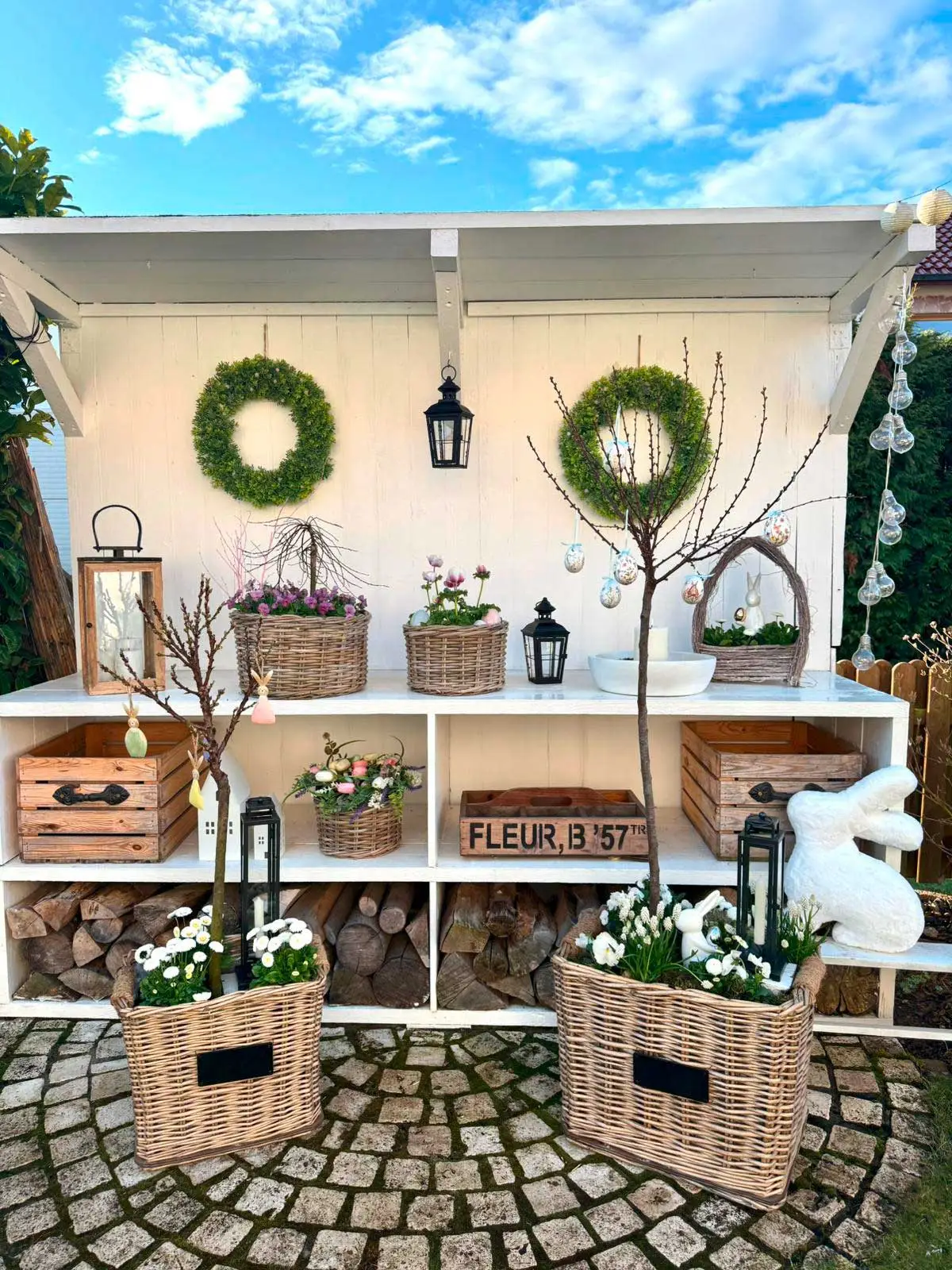 Décoration printanière : paniers en osier garnis de fleurs et de couronnes vertes pour décorer le jardin
