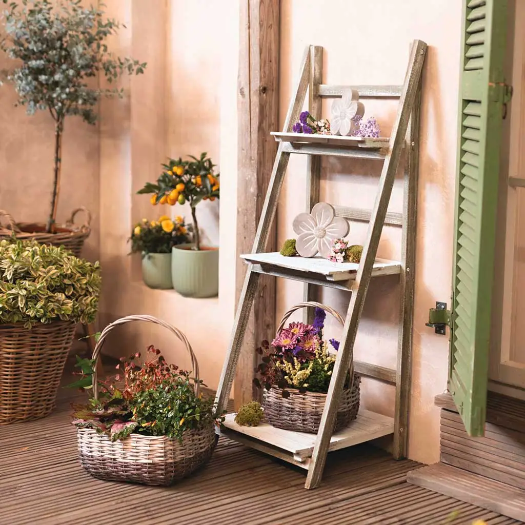 Décoration de jardin : échelle en bois gris avec des paniers et des fleurs, servant d'escalier décoratif pour plantes