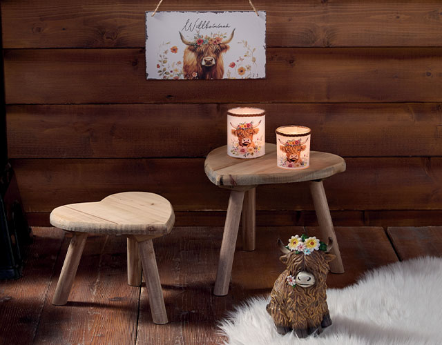 Décoration de chalet : tabourets en bois, bougies et motif de bœuf des Highlands pour une décoration rustique de style alpin