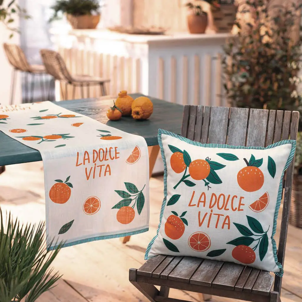 Linge de table : coussin et chemin de table blancs à motif d'oranges pour une décoration de terrasse méditerranéenne
