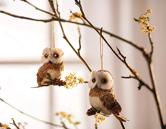 Décoration d'automne : des pendentifs en forme de chouettes fabriqués à partir de matériaux naturels, accrochés à des branches, pour une décoration d'automne originale