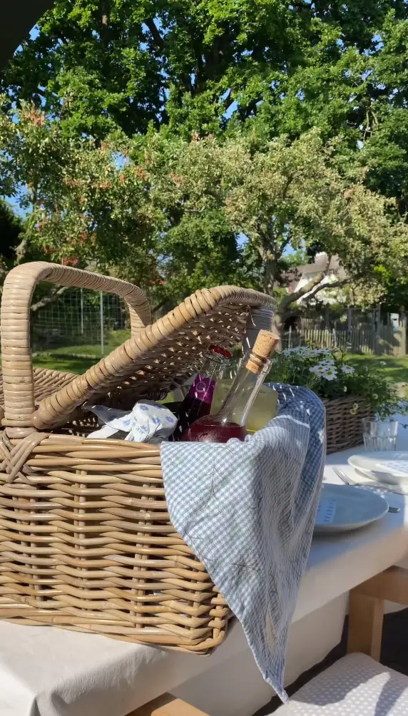 Panier de pique-nique : panier tressé contenant des boissons et de la vaisselle, idéal pour les moments estivaux au jardin