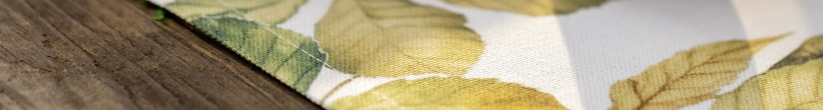 Textiles d'intérieur : tissu aux motifs de feuilles d'automne dans les tons verts et dorés, idéal pour une décoration de saison