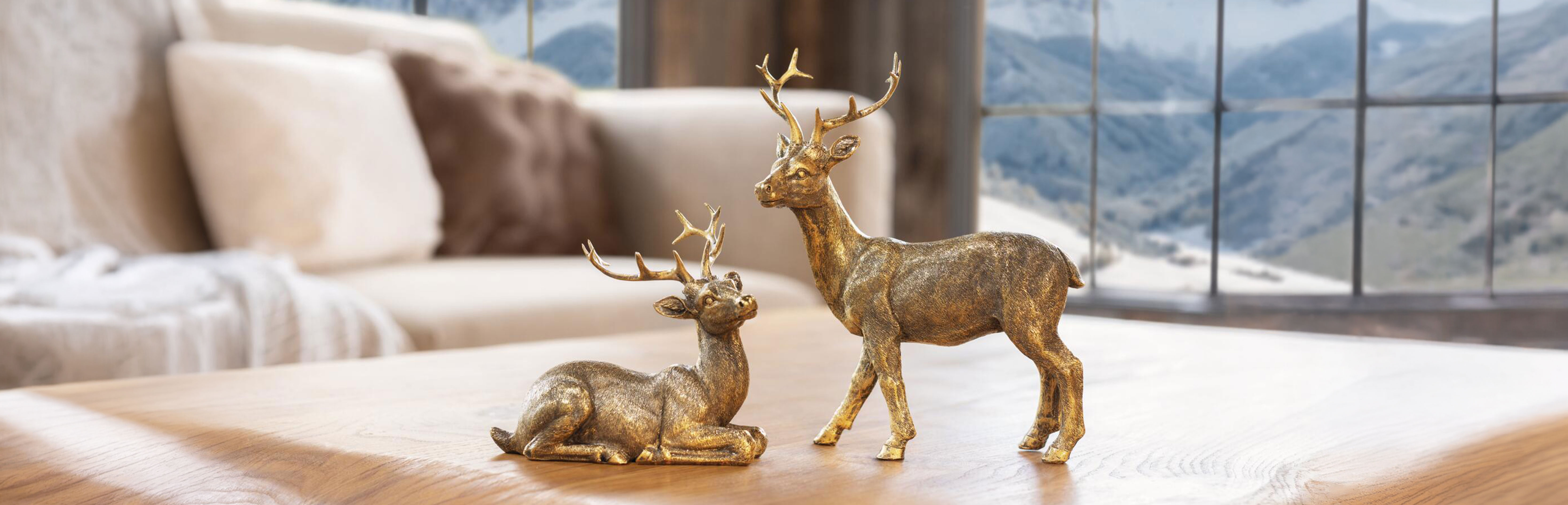 Décoration de Noël : des figurines de cerfs dorées posées sur une table en bois, pour une décoration hivernale élégante dans le style chalet